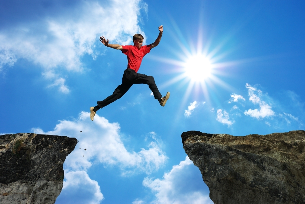 man jumping over cliff